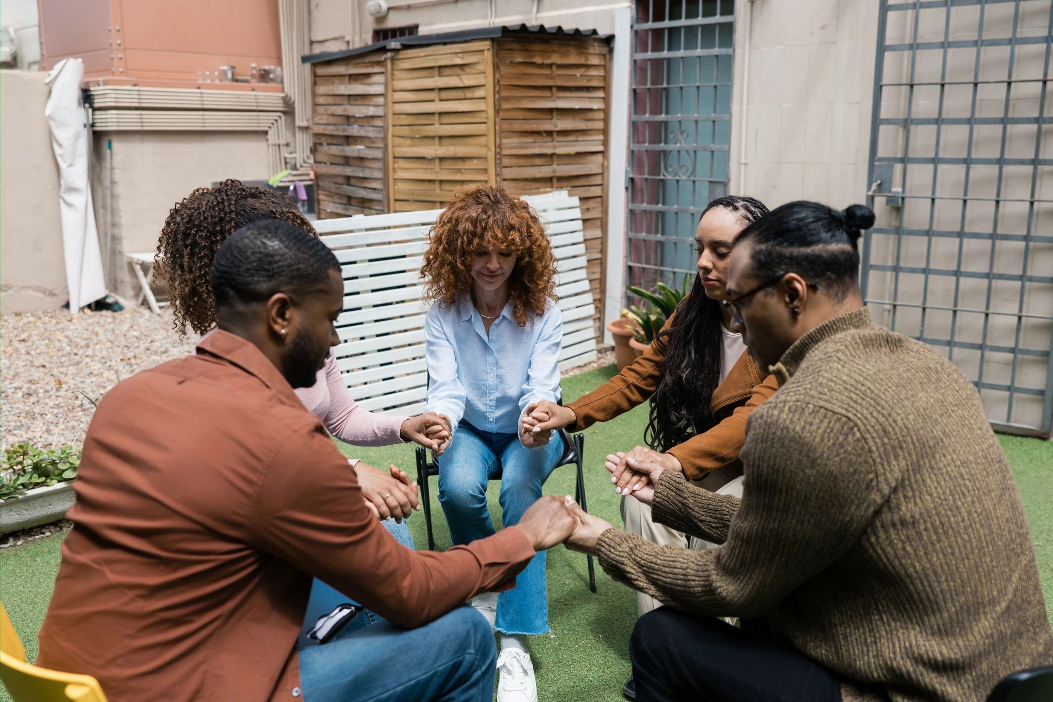 People joining hands in support during therapy